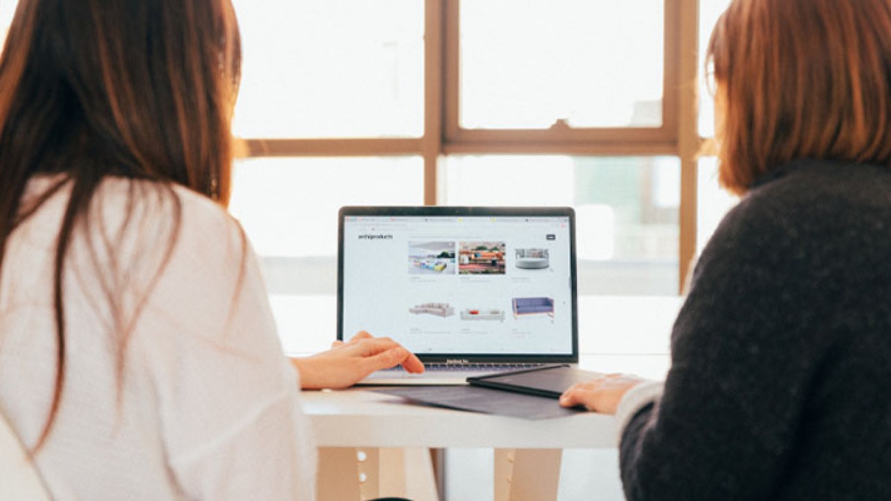 two women looking at a laptop