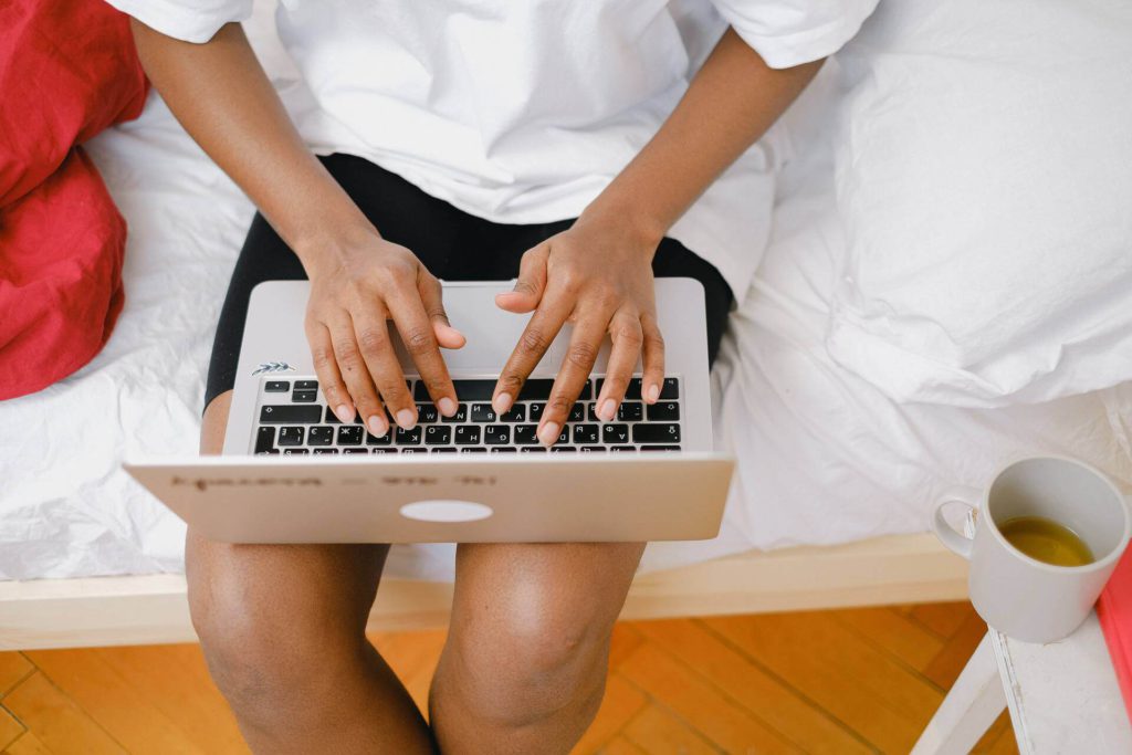 laptop on woman's lap, her hands typing